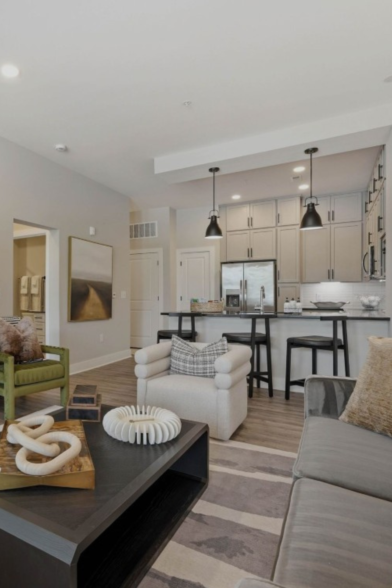 The Sloan at LoSo apartments in Charlotte, NC bedroom with bed, gray comforter, pillows, side table, and lamp