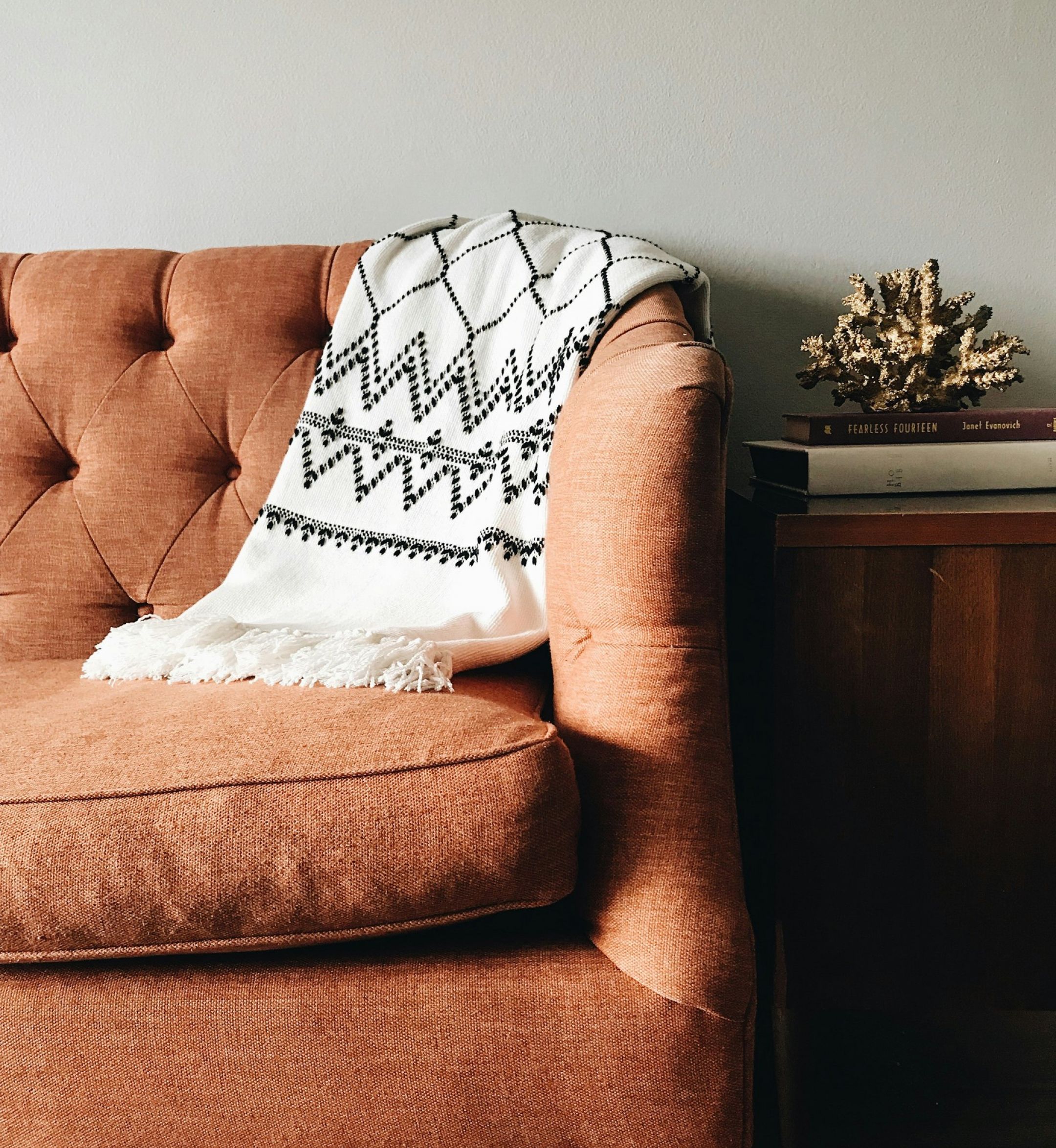 The Sloan at LoSo apartments in Charlotte, NC - close up of orange couch with throw blanket